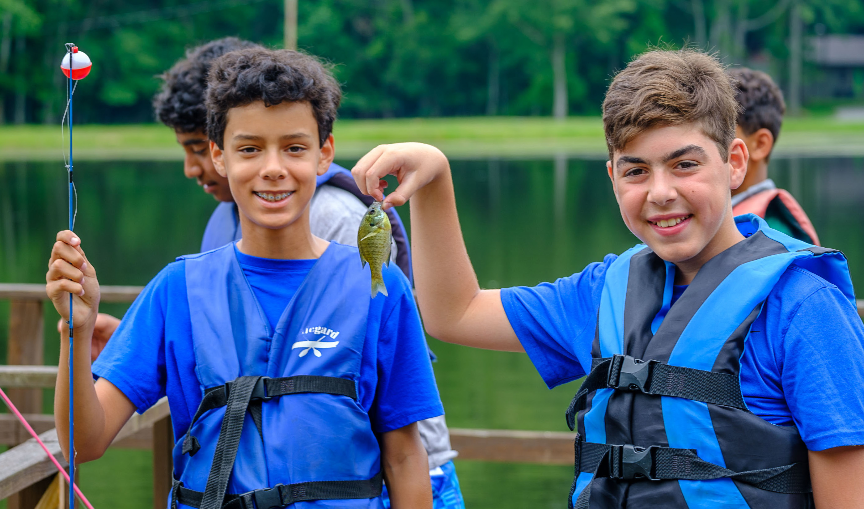 Two boys showing off the day's catch, fishing at 4-H Camp